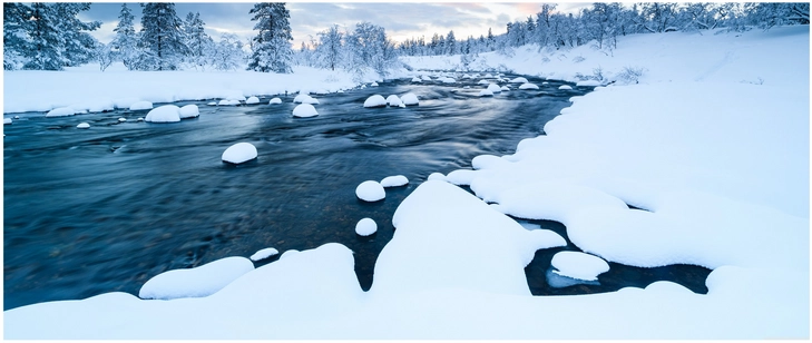 winterlandschaft mit fliessendem bach und schneebedeckten felsen