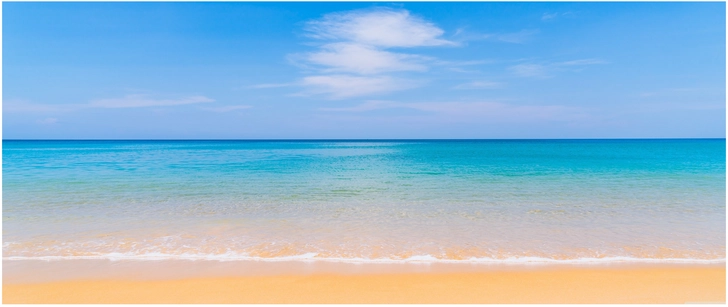 wunderschoener strand mit klarem wasser und blauem himmel