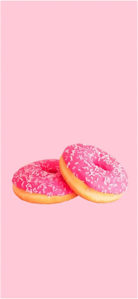 zwei pinke donuts mit streuseln auf pastellfarbenem hintergrund